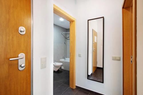 een badkamer met een toilet en een spiegel bij Apartamento Oceano in Albufeira