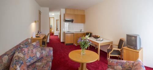 a living room with a couch and a table with flowers at Landidyll Hotel Lamm in Vaihingen an der Enz