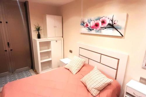 - une chambre avec un lit et une peinture murale dans l'établissement Apartamento Playa Foz, à Foz