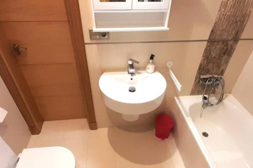 La salle de bains est pourvue d'un lavabo, de toilettes et d'une baignoire. dans l'établissement Apartamento Playa Foz, à Foz