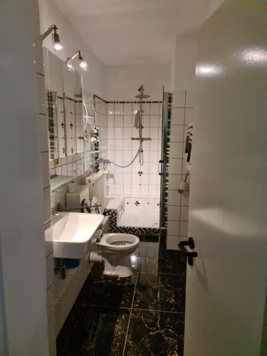 ein Badezimmer mit einem Waschbecken, einem WC und einer Badewanne in der Unterkunft Hotel Sofia in Bad Wildungen