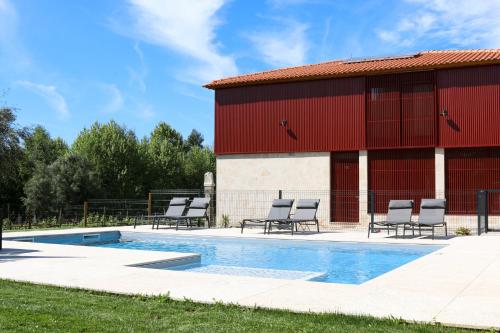 a pool with chairs next to a building at Quinta de Chousas - Braga - Agroturismo in Braga
