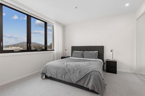 a white bedroom with a bed and a large window at Phenomenal Stay In Phillip in Phillip