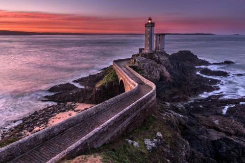 a lighthouse on the rocks near the ocean at sunset at Saint-Pierre - 3 chambres - WIFI - Spacieux - Neuf in Brest