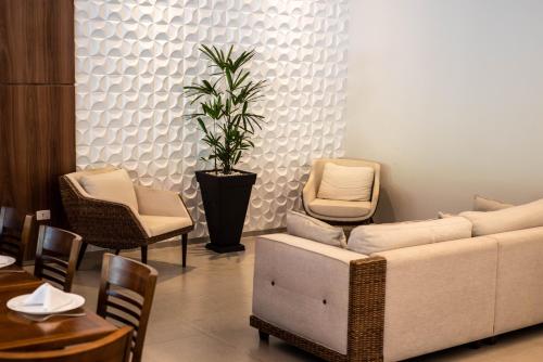a living room with a couch and chairs and a table at Sumaré Park Hotel in Sumaré
