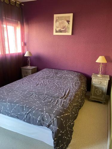 1 dormitorio con cama y pared púrpura en Chez Francoise, en Le Barcarès