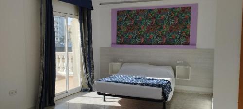 a bed in a room with a painting on the wall at Hvalles in Malgrat de Mar