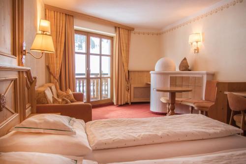 Habitación de hotel con cama y ventana en Natur-&Alpinhotel Post en Vent