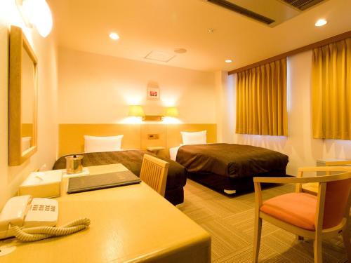 a hotel room with a bed and a desk at Okano Hotel in Sendai