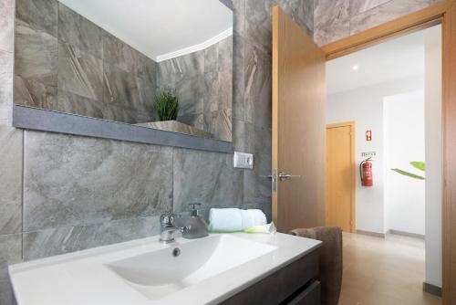 a bathroom with a white sink and a mirror at Capelas Pdl Apartment in Capelas