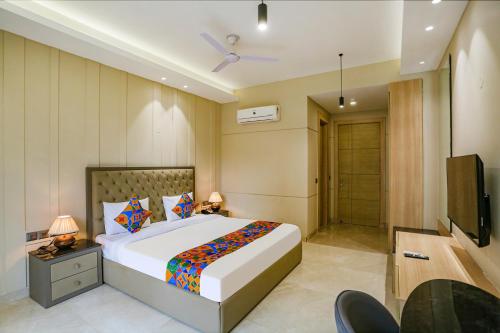 a bedroom with a large bed and a television at FabHotel Infinity Stay II in Gurgaon