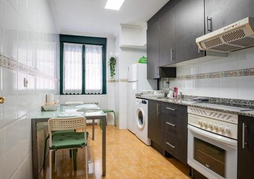 a kitchen with a counter and a table and a dishwasher at Apartamento céntrico con wifi y parking de coche tamaño medio in Cangas de Onís