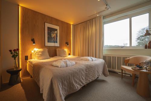 a hotel room with a bed and a large window at Skepparholmen Nacka in Nacka