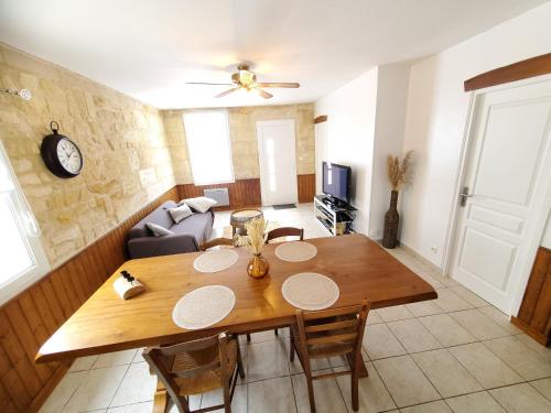 a living room with a wooden table and a couch at Maison de vacances Gite le Margot in Cantenac