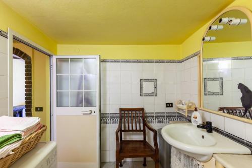 a bathroom with a sink and a mirror and a chair at Destinazione Paradiso in Grondola