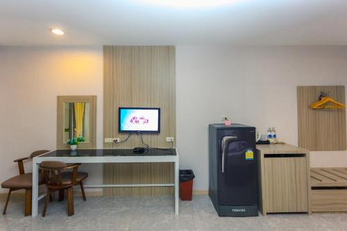 a room with a desk and a refrigerator in a room at Embryo Hotel  in Pattaya Central