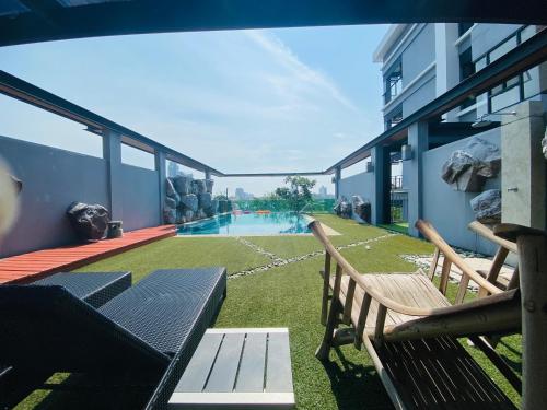 een balkon met twee banken en een zwembad bij Le Vernissage by Goad Avadhess Hospitality in Pattaya