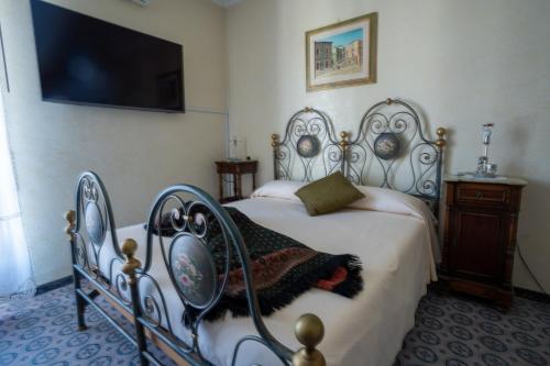 a bedroom with a bed and a flat screen tv at Maison Manni' B&B in Soverato Marina