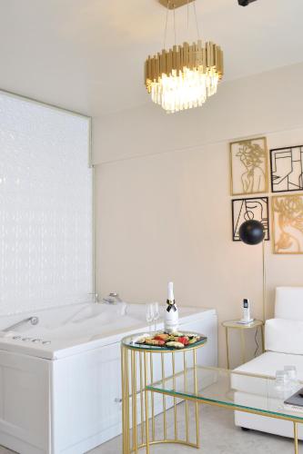 a living room with a glass table and a chandelier at John's Hotel in Chalkida
