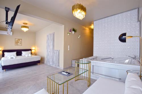 a room with a tub and a bed and a table at John's Hotel in Chalkida