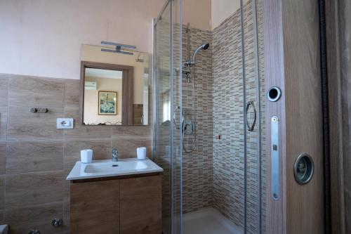 ein Bad mit einer Glasdusche und einem Waschbecken in der Unterkunft Maison Manni' B&B in Soverato Marina