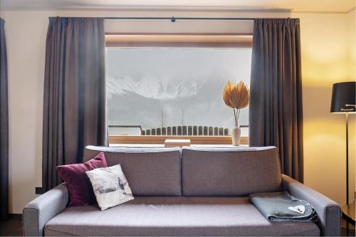 a living room with a couch and a window at Angerle Alm Apt König Laurin in Carezza al Lago