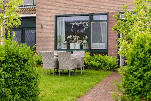 a table and chairs in a yard with a window at B&B Molenaar in Buren