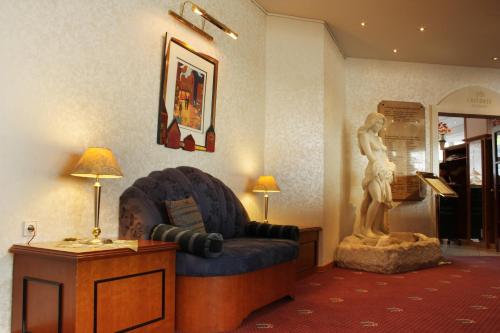 a living room with a statue of a man playing the piano at Parkhotel Altmühltal in Gunzenhausen