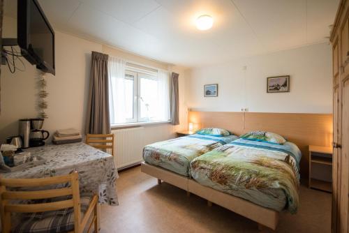 sypialnia z łóżkiem, stołem i oknem w obiekcie B&B Molenaar w mieście Buren