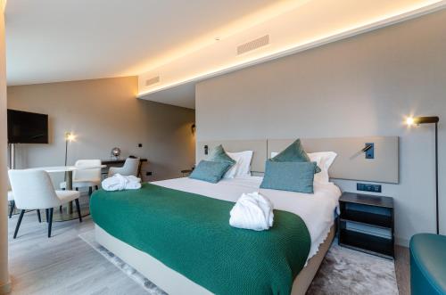 a hotel room with a large bed and a table at OMID Saldanha Hotel in Lisbon