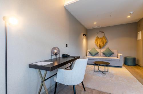a living room with a table and chairs and a couch at OMID Saldanha Hotel in Lisbon