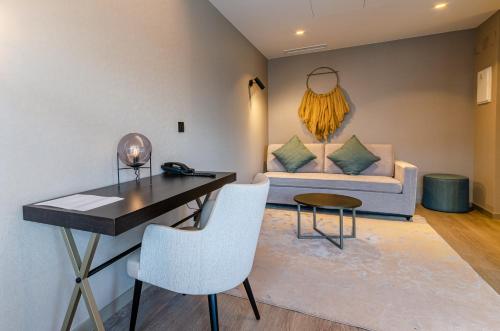 a living room with a couch and a table and chairs at OMID Saldanha Hotel in Lisbon