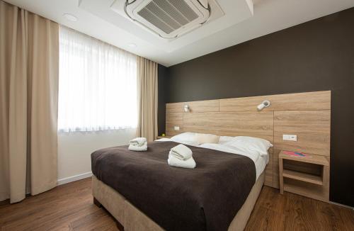 1 dormitorio con 1 cama grande y 2 toallas. en Residence Šírava *** en Kaluža