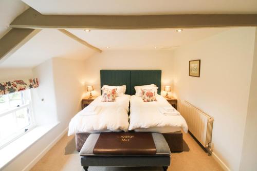 a bedroom with a bed with a green headboard at Red Squirrel Cottage, Hutton in Penruddock