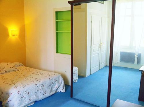 - une chambre avec un miroir à côté d'un lit dans l'établissement T2 à pied de plage sur ancien hôtel chic, samedi a samedi, à Saint-Jean-de-Luz