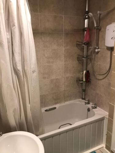 a bathroom with a bath tub and a toilet at Stoddart House in Newcastle upon Tyne