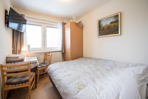 a bedroom with a bed and a desk and a window at B&B Molenaar in Buren