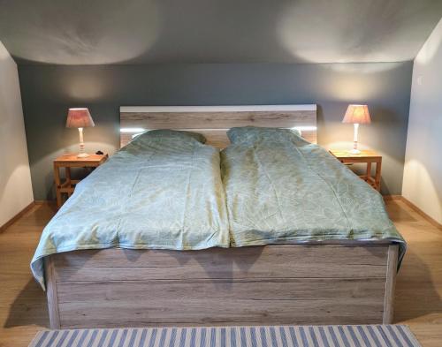 ein Bett in einem Schlafzimmer mit zwei Lampen an zwei Tischen in der Unterkunft vakantiehuis Zidanica in Žužemberk