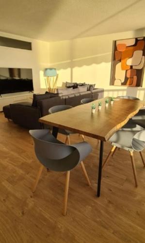 un salon avec une table et des chaises en bois dans l'établissement Les terrasses de Beausoleil, à Beausoleil