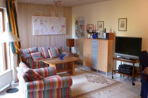 a living room with two chairs and a television at Ferienwohnung Rehgarten in Momlingen