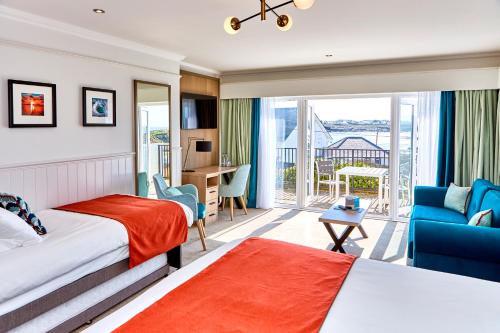 a hotel room with a bed and a balcony at Trearddur Bay Hotel in Trearddur