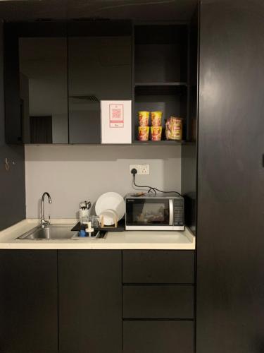 a kitchen counter with a sink and a microwave at AmicaHomes Studio 3 Empire City Free wifi & Netflix in Petaling Jaya