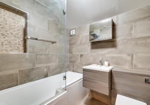 W łazience znajduje się umywalka, prysznic i wanna. w obiekcie Clematis Cottage w mieście Sandsend