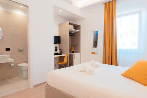 - une chambre avec un lit blanc et une salle de bains dans l'établissement Liolá Cefalù, à Cefalù