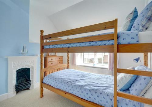 1 Schlafzimmer mit 2 Etagenbetten und einem Kamin in der Unterkunft Cheyne Cottage in Hawsker