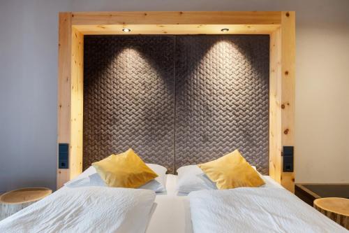 una camera da letto con un grande letto con due cuscini gialli di Angerle Alm Apt Similde A a Carezza al Lago