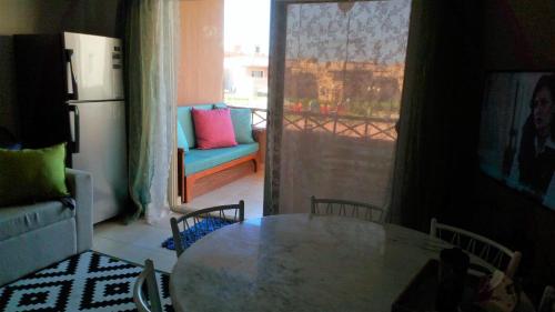 cocina con mesa, sillas y nevera en Deluxe cozy chalet in Malibu Sokhna, en Ain Sokhna