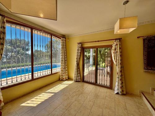 a room with large windows and a view of a pool at Villa la Parreta REF.025 in Benicàssim