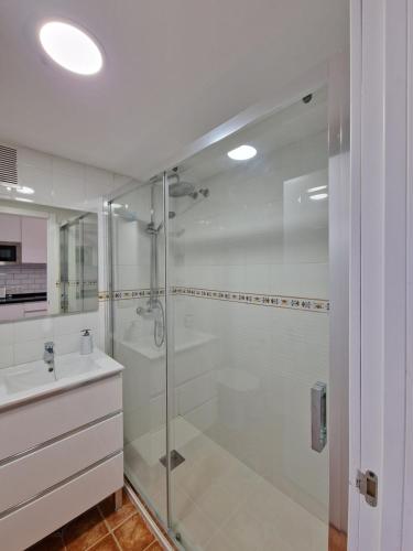 y baño con ducha acristalada y lavamanos. en G&G Benalbeach Mediterranean Terrace, en Benalmádena