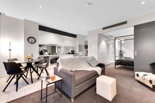 a living room with a couch and a table at Opulent Level 25 Condo with Breathtaking Views in Melbourne